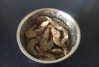 放入少许的盐腌制5分钟左右，放入10g的淀粉，晃动容器，将淀粉均匀的裹在大虾上。