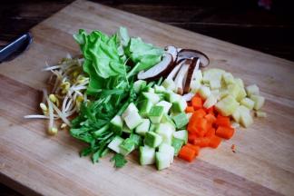 将黄豆芽清洗干净，圆白菜撕成块，泡发好的木耳撕成小朵，茼蒿切成段，香菇切成片，土豆和胡萝卜及小西葫切成丁。