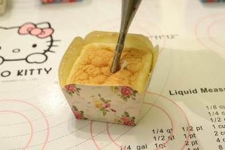 从中间将卡士达酱挤入蛋糕体内。