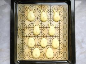 把画着皮卡丘图案的纸垫在油布或马卡龙垫下面，用小花嘴画出耳朵，大花嘴挤出身体。震动几下烤盘，放在烤箱中开30度热风，将表面稍吹干到不粘手的状态。（如果烤箱没有热风功能，在室温通风处静置15-30分钟左右也可以）
