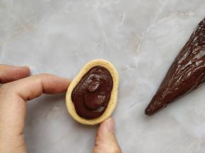 将做好的甘那许内馅装入剪口裱花袋，挤在背面的那一片上，盖上皮卡丘的正面，放入冰箱密封冷藏至隔夜食用即可。