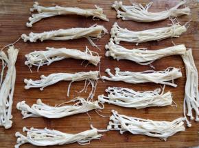 分成约小指粗的组。金针菇不要贪多，否则不容易嚼烂，以一口的量为准。金针菇焯水可以去除杂质和异味，而且节省烹调时间，以免外层的包菜不脆。