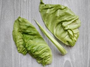 包菜（牛心菜）洗净，掰出几层叶子。茎如图切掉，只用两边的叶子，每片叶子再分成两个长条。