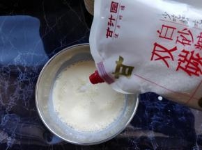 倒入细砂糖或糖粉，搅匀。这里需要注意，不要在蛋黄里直接加入细砂糖，很容易结块。要让细砂糖搅匀溶解在牛奶和淡奶油里。