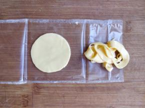 取一片切达早餐奶酪，剥掉表面包装，用比蛋挞直径稍小的杯口扣出圆形。