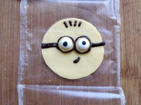 将黑巧克力装入剪口裱花袋，画出小黄人的其他部分。