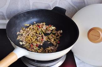 加入榨菜丝略翻炒后再加入红椒段。我用的红椒微辣，建议您也不要用太辣的，否则会抢了榨菜的鲜香之气。然后就可以出锅了