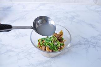 在榨菜肉丝中放入适量香菜，再将一勺热面汤浇入拌匀。