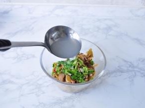 在榨菜肉丝中放入适量香菜，再将一勺热面汤浇入拌匀。