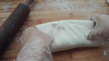 将撒上干粉的面片进行三折，如图所示