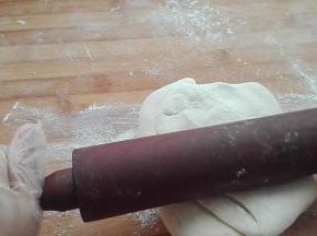 继续再次三折，然后接着用擀面杖将其继续擀开