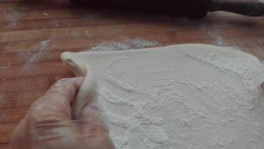 擀好后，继续撒干面粉，均匀抹在面片上