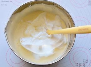 然后将混合好的面糊全部倒入剩余的蛋白霜里，刮刀画Z字形快速翻拌均匀。