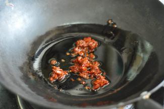 锅里倒入油，放入郫县豆瓣酱炒出红油。