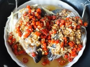 将热好的剁椒铺在蒸好的鱼头上