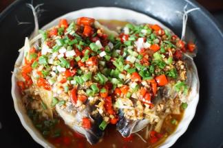 在鱼头上撒上葱花