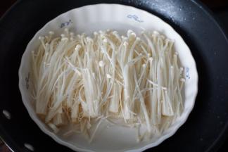 金针菇去头部分，洗净后披在盘里上锅蒸至金针菇变软