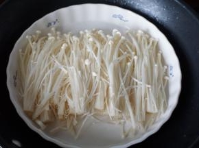 金针菇去头部分，洗净后披在盘里上锅蒸至金针菇变软