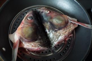 鱼头放在网蒸架上锅蒸至鱼眼睛变白，取出，倒去蒸鱼的水