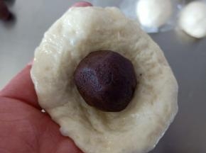 7包入豆沙馅，全部包好后盖保鲜膜松弛15分钟
