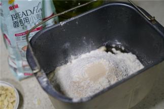 然后将金龙鱼面包用小麦粉配在桶里，再加加入称量好的酵母。