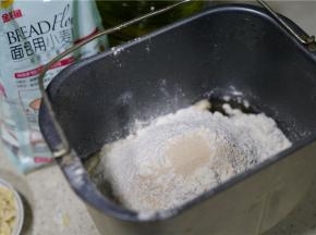 然后将金龙鱼面包用小麦粉配在桶里，再加加入称量好的酵母。
