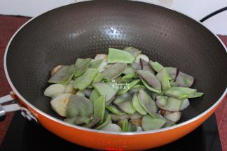 加入洗净的切好的眉豆，翻炒一下；让眉豆和芋儿都炒出香味。