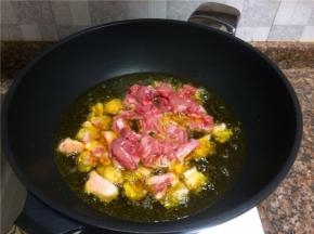 放入鸡翅和兔肉煸干水份。