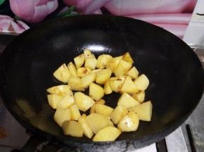锅内加油烧热至四成倒入土豆煎至表皮金黄捞出备用