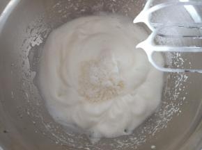 7. 蛋白霜打发至出现明显的纹路时加入剩下的细砂糖，用硅胶刮刀把周围的蛋白霜刮一下，打蛋器搅拌一下，然后开低速打发
