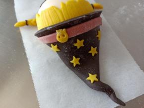 15.取一条粘到帽子下方，并用黄色面团做装饰
