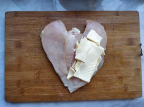 将早餐奶酪片撕成小块，夹在鸡胸肉中间。尽量往中间塞，不要超出鸡肉边缘，否则烤的时候很容易流出来。