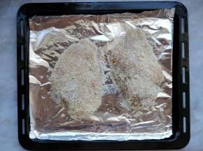 然后依次在蛋液和面包糠里滚一下，抖掉多余的部分，放到烤盘上。黑色烤盘有不粘涂层，但是为了清理方便，可以垫上油纸或锡纸。