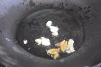 锅里倒入油，放入蒜和姜炸香。