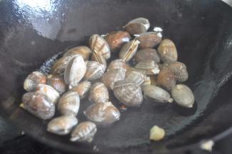 放入控干水的蛤蜊翻炒。