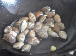 放入控干水的蛤蜊翻炒。
