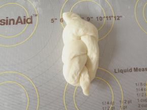 下半部分的面团往右拧下，然后上面的从洞口穿进去整理好放进模具中