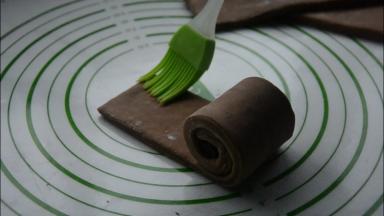 将面片紧紧卷起，在另一端刷刷一点水，卷好。