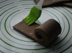 将面片紧紧卷起，在另一端刷刷一点水，卷好。