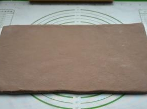 用擀面杖将面团擀开，慢慢用力擀成厚度均匀的面片，避免擀破，初次擀面团可切掉边缘不整齐的部分，这样成品层次会更好些。