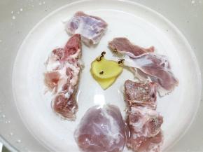 锅里加入猪骨，猪展肉，姜片，花椒粒，清水