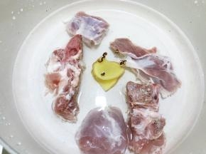 锅里加入猪骨，猪展肉，姜片，花椒粒，清水