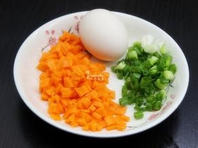 在等待蒸饭的过程，把胡萝卜去皮切粒、香葱洗净切好；