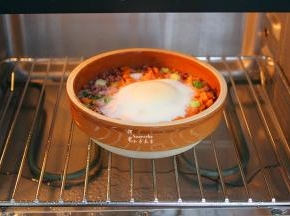 把米饭放回蒸烤箱，关上蒸烤箱的门，直到烹饪时间结束取出，表面撒些葱，即可。