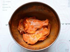 鸡大腿清洗干净，切成两块，放入奥尔良烤肉料腌制4个小时以上