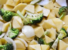 蔬菜全部放入烤盘里面，倒上2大匙橄榄油，撒上适量的黑胡椒翻拌一下