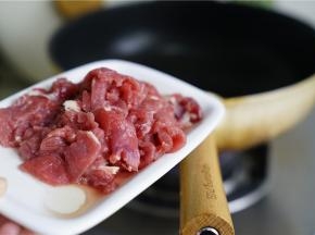 锅里加适量的油，将用油腌过的牛肉下锅微微炒一下。