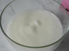蛋清用打蛋器打发至出现鱼眼泡泡，倒入三分之一细砂糖B，继续打发。