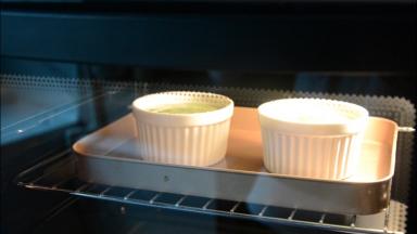 把舒芙蕾模具放在烤盘里，放入烤箱中层烤制。