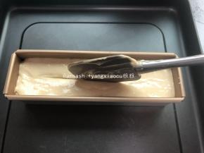 将面糊倒入模具中，将模具轻轻敲几下震出气泡